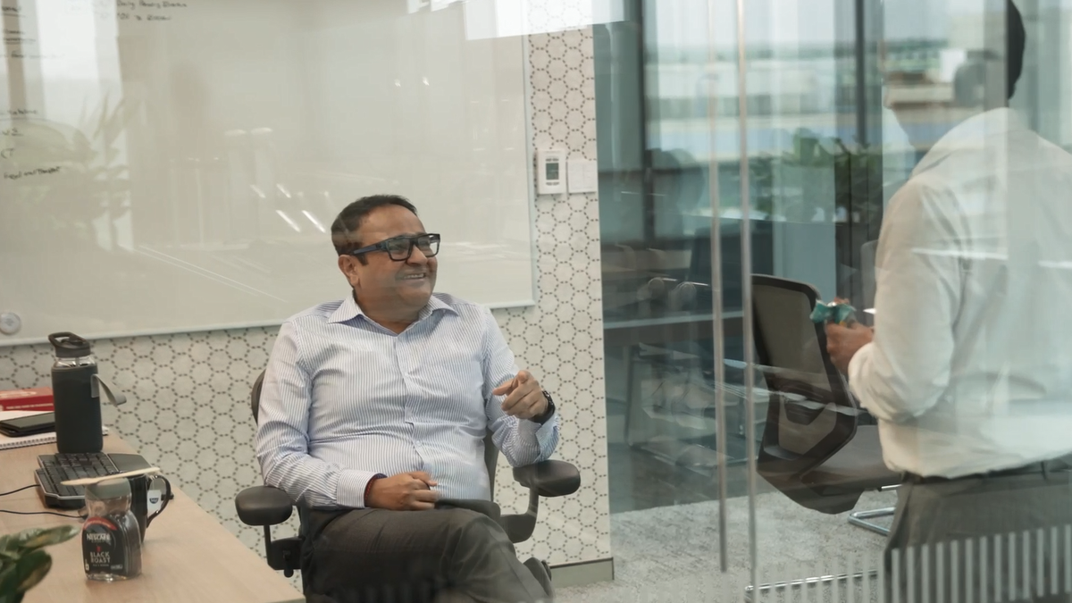 Apollo employees meeting in an office with a glass wall 