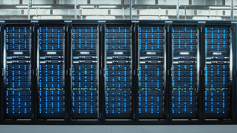 Row of illuminated data servers in a modern data center, representing scalable infrastructure essential to digital growth and capital markets origination.
